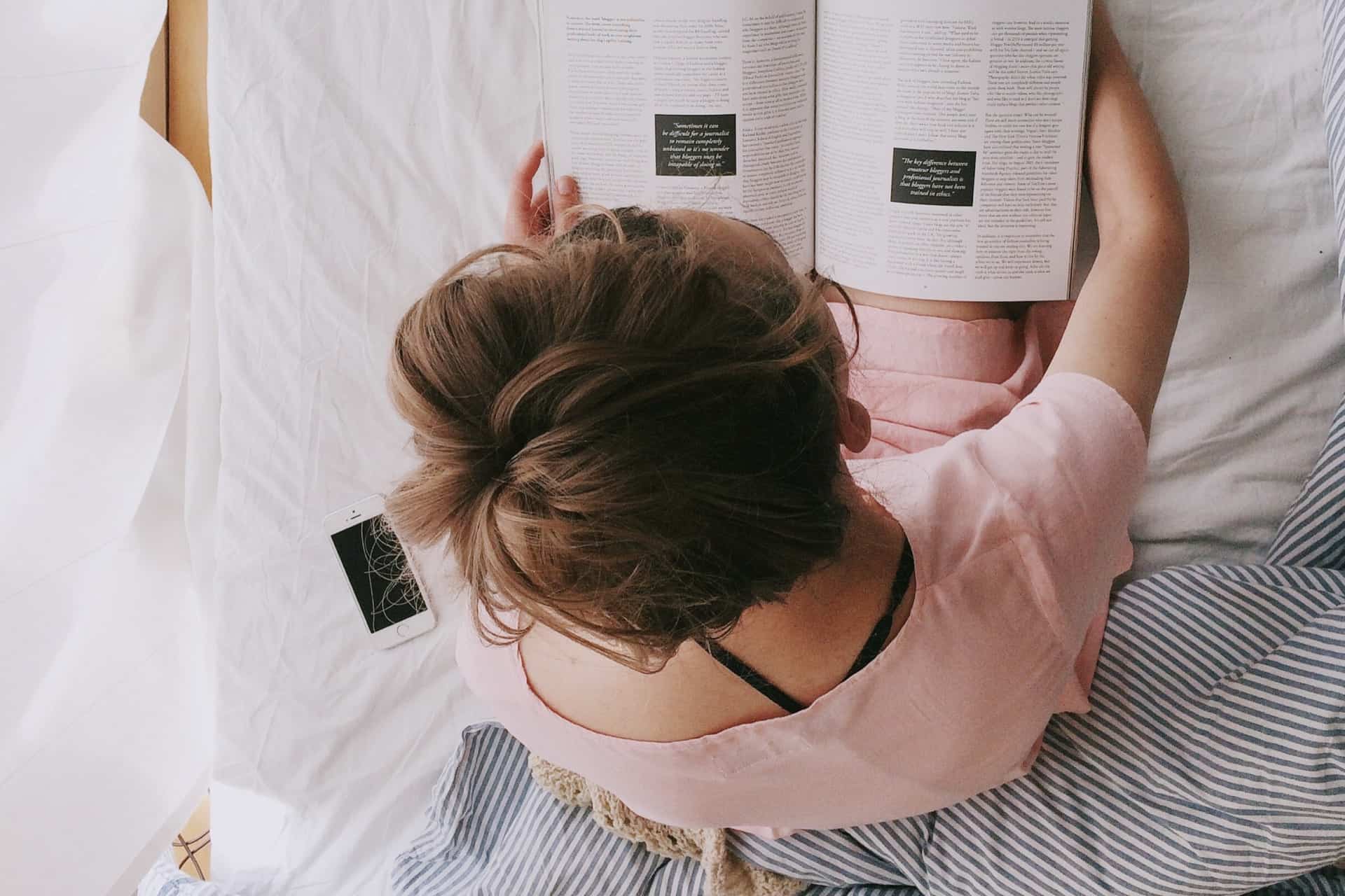 woman in pink dress sitting on bed while reading 698158 - 5 Things That Will Help Mom Relax
